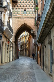 Archway street Mudéjar architecture of Torre de El Salvador church tower, city of Teruel, Aragon,