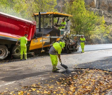 Asphalt road construction team of workers resurfacing tarmac in rural area, near Albarracin, Teruel