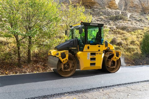 BOMAG compactor machine asphalt road construction resurfacing tarmac in rural area, near