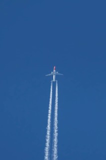 Boeing 737 jet passenger aircraft of Norwegian Air airlines flying in a blue sky with contrails or