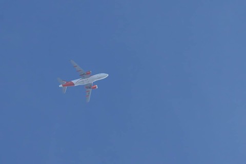 Airbus jet passenger aircraft of Easyjet airlines flying in a blue sky, England, United Kingdom