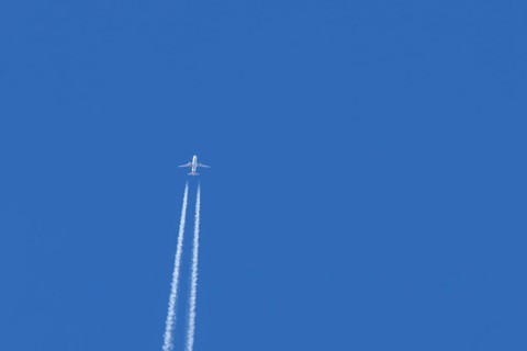 Airbus jet passenger aircraft of Easyjet airlines flying in a blue sky with contrails or vapour