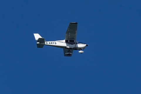 Cessna 172C Skyhawk light aircraft flying in a blue sky, England, United Kingdom