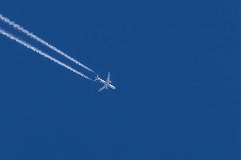 Airbus jet passenger aircraft of Eurowings airlines flying in a blue sky with contrails or vapour