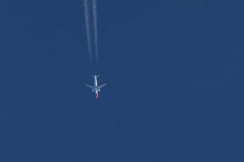 Boeing 737 jet passenger aircraft of Norwegian Air airlines flying in a blue sky with contrails or