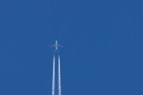 Airbus jet passenger aircraft of Kuwait airways flying in a blue sky with contrails or vapour