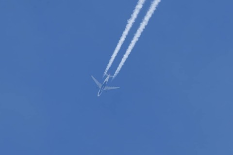 Jet passenger aircraft of Delta airlines flying in a blue sky with contrails or vapour trails