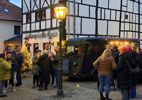People at the decorated half-timbered house of the restaurant et Kemp'sche huus in the evening, Old