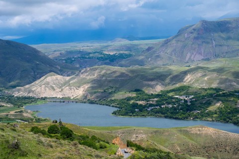View of a lake nestled in mountainous landscape under cloudy sky, landscape with Shamb Reservoir