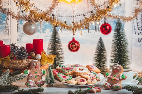 Christmas table with cookies, balls and decoration in front of snowy landscape