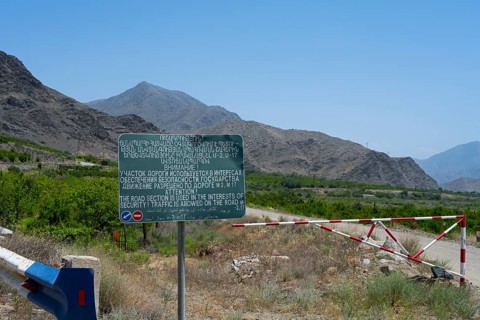 A sign and a barrier are on a road with safety warnings, sign on the M17 road that runs along the