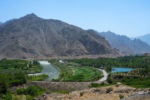 A river snakes through a lush landscape with mountains, views of Iran, Aras River near Meghri,