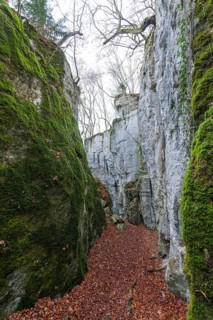 The climbing trail through the rocks and caves of hell holes in the autumnal landscape of Dettingen