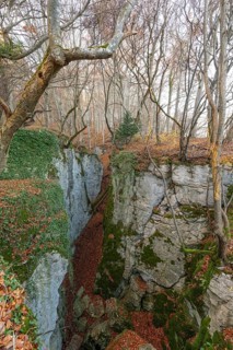 Low sun illuminates the rocks and caves of hell holes in the autumnal landscape of Dettingen an der