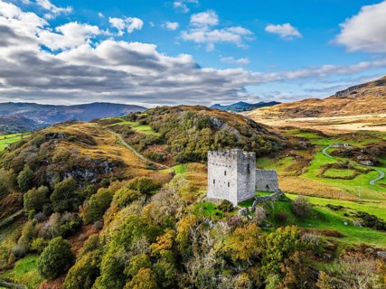 Autumn colours over Castell Dolwyddelan and Eryri Mountains from a drone, Snowdonia, Conwy County