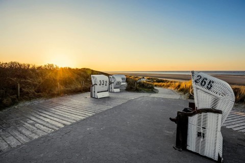 Beach chairs in the dunes and blue sky in winter, sunset, Spiekeroog, East Frisian Islands, Lower