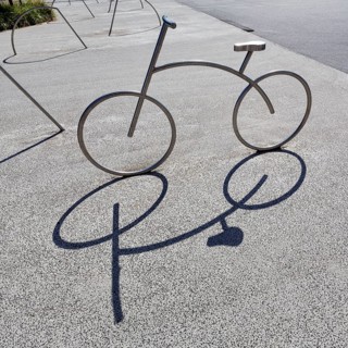 Bicycle, stainless steel bicycle rack, casts shade, bicycle parking, Aalborg, Jutland, Denmark
