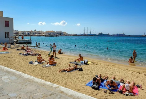 Mykonos, Cyclades, Greece - Tourists and locals like to bathe at the small town beach Paralia