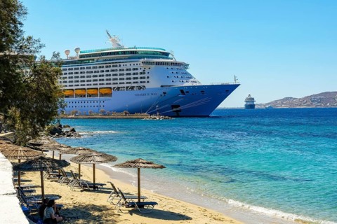 Mykonos, Cyclades, Greece - Voyager of the Seas cruise ship is located in Mykonos Harbour Bay.