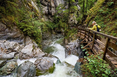 Female hiker on wooden walkway on the Diosaz mountain river in the gorge, Gorges de la Diosaz, Les