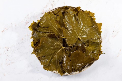 Canned grape leaves, for cooking dolma, on a plate