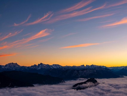 Red-colored plume clouds over the Berchtesgaden Alps at dusk, fog in the valley, Hochstaufen,