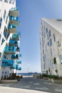 Distinctive white residential complex, turquoise balconies against blue sky, pyramid-shaped