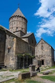 Old church with a distinctive tower and massive stone walls, divided into various building