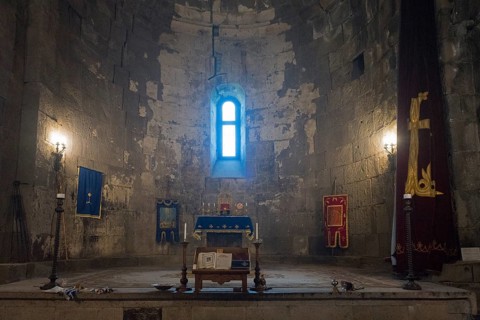 Illuminated church interior with altar, window and candles, filled with sacred atmosphere and