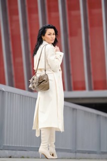 A woman confidently strolls down a modern urban street during autumn, she stopped and look back