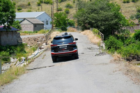 An SUV crosses a damaged bridge in a green, rural area, Toyota Fortuner on bridge over the Debed