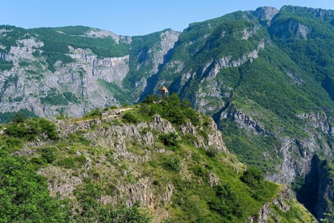 Small rotunda on a green mountainside with majestic rock formations, Halidzor observation deck,