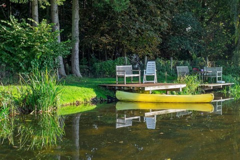 A jetty with benches and a yellow canoe on a quiet river, Dinkel River, Heek-Nienborg, Münsterland,