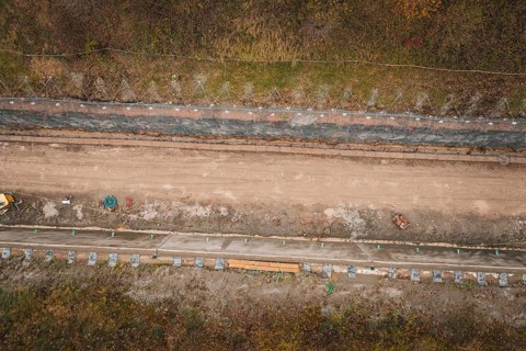 Aerial view of a construction site in an autumn area with construction along a path, construction