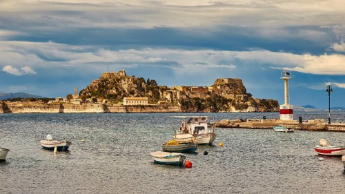 View of an island with fortress and small boats in the water under cloudy sky, UNESCO World