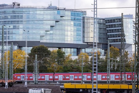 Modern architecture of the Mercedes-Benz Van Technology Center (VTC), in front of it an S-Bahn and