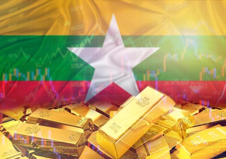 Gold bars on Myanmar flag in background. Gold bars stacked on Burmese flag. Concept of Myanmar gold