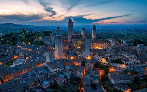 City view of San Gimignano at dusk, gender towers and medieval buildings, Tuscany, Italy
