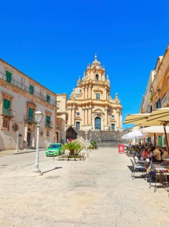 Tourists sitting in local restaurants in the main square, Ragusa Ibla, Ragusa province, Sicily,