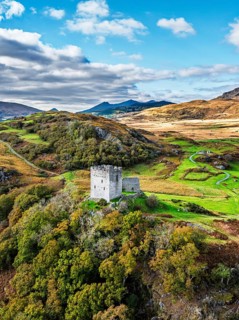 Autumn colours over Castell Dolwyddelan and Eryri Mountains from a drone, Snowdonia, Conwy County
