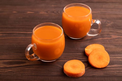 Two glasses with carrot juice, on wooden background. Diet, healthy eating concept. side view, close