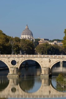 Bridge over the river Tiber with the dome of St. Peter's Basilica in the Vatican city in the