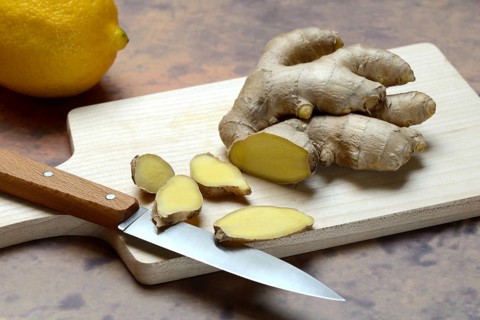 Ginger, ginger root cut with ginger slices on wooden boards