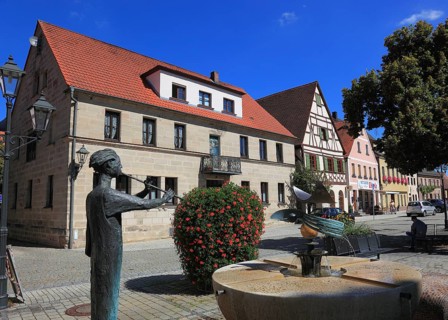 Half-timbered houses and fountain figure flute player, on Rathausplatz, city of Heideck in the