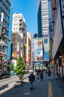 Street scene with skyscrapers, figure Godzilla head on a skyscraper, Shinjuku City, Tokyo, Japan