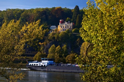 Marienfels Castle with cargo ship on the Rhine River, former residence of entertainer Thomas