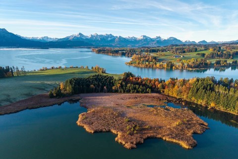 Autumn landscape with a lake surrounded by trees and mountains, Illasbergsee, Forggensee, near