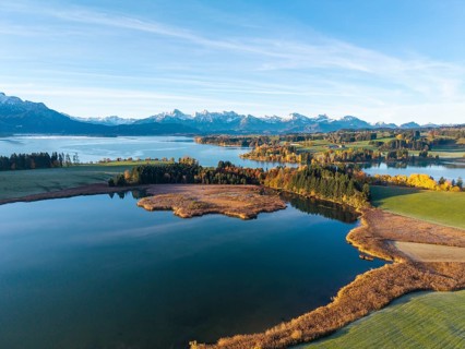 Quiet lake with autumnal shore and mountain panorama in the background, Illasbergsee, Forggensee,