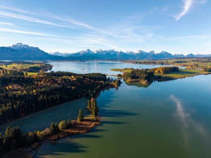 Clear reflections of a quiet lake surrounded by forests and mountains in autumn, Illasbergsee,