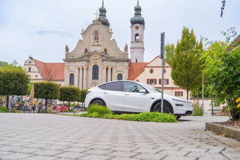 A modern car is parked in front of a historic church in the city center, ZFP Zwiefalten, Reutlingen